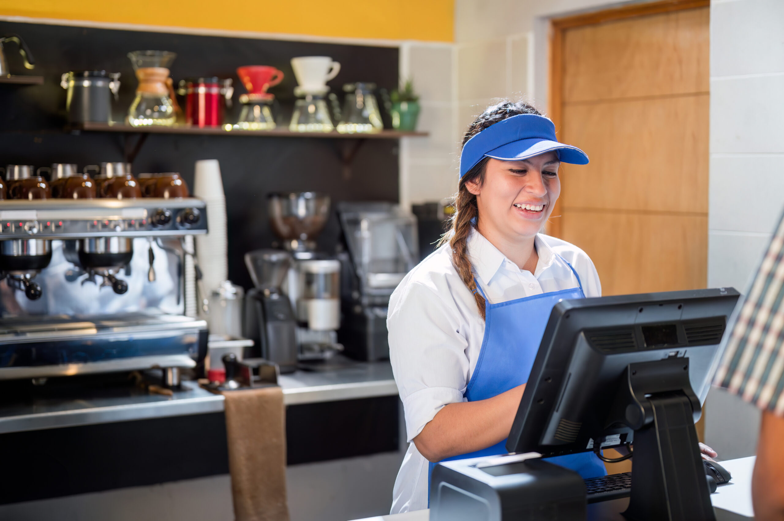 Latina woman takes the order of a Latino customer who has come to buy products at the coffeeshop.